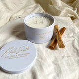 Palo Santo Candle in a decorative tin with  on a light fabric background